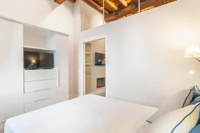a white bedroom with a bed and a tv at Ciambella Atmosphere by Rental in Rome in Rome