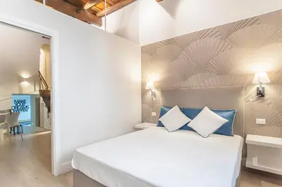 a bedroom with a bed with blue and white pillows at Ciambella Atmosphere by Rental in Rome in Rome