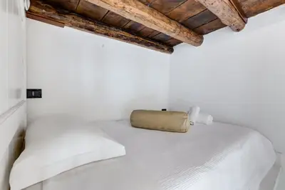 a bedroom with a white bed with a bag on it at Dream Home in Rome