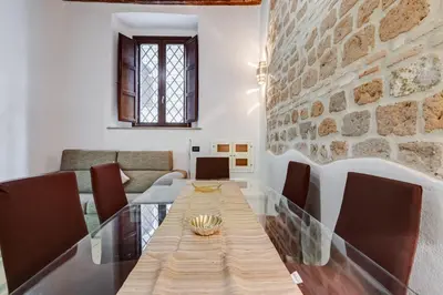 a dining room with a table and a stone wall at Dream Home in Rome
