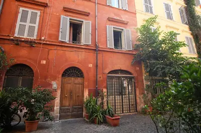 an orange building with a wooden door and windows at C&A Apartments - Authentic Trastevere in Rome