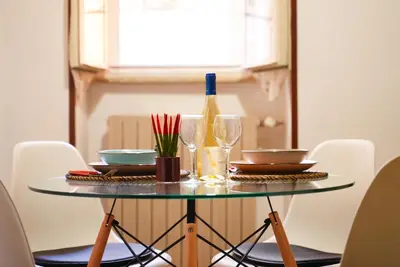 a table with glasses and a bottle of wine at C&A Apartments - Authentic Trastevere in Rome