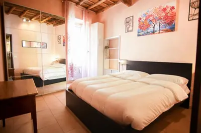 a bedroom with a large bed and a mirror at C&A Apartments - Authentic Trastevere in Rome