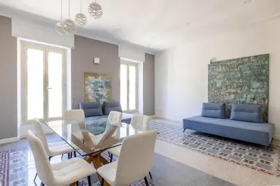 a dining room with a glass table and white chairs at Coppedè Luxury Apartment in Rome