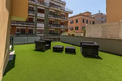 a patio with green grass and chairs on a balcony at Appia Antica Park - Apartment with Terrace in Rome