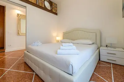 a bedroom with a white bed with a mirror at Appia Antica Park - Apartment with Terrace in Rome