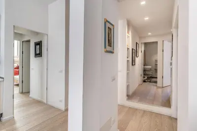 an empty hallway with white walls and wood floors at Fresh House Fori Imperiali in Rome