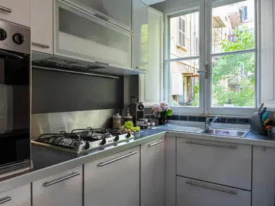 a kitchen with white cabinets and a stove top oven at Domus Alexander, Terrace Downtown Apartment in Rome