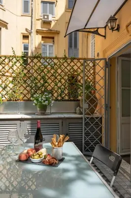 a table with a plate of food and a bottle of wine at Domus Alexander, Terrace Downtown Apartment in Rome