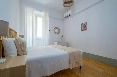 a white bedroom with a bed and a window at ht la spezia bilo in Rome