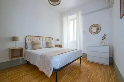 a white bedroom with a bed and a dresser at ht la spezia bilo in Rome