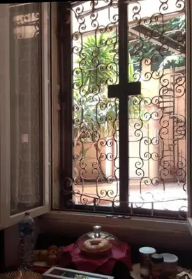 a blue building with three windows and a tree at crescenziovaticanflat in Rome
