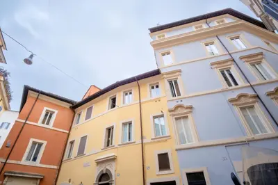 a yellow and white building in a city at Elegantis Trevi Suite Apartment - Just 50m from Trevi Fountain in Rome