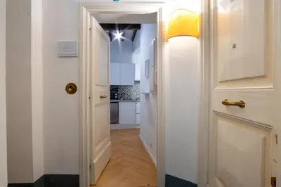 a hallway with a white door and a kitchen at Elegantis Trevi Suite Apartment - Just 50m from Trevi Fountain in Rome