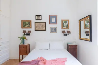 a bedroom with a white bed and pictures on the wall at iFlat Campo de' Fiori Brand New & Bright apt in Rome