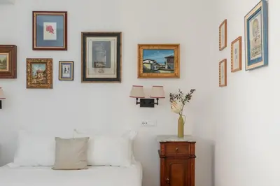 a bedroom with a white bed and pictures on the wall at iFlat Campo de' Fiori Brand New & Bright apt in Rome