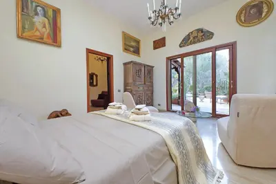 a bedroom with a large white bed with a chandelier at Luxury Trastevere Terraces in Rome