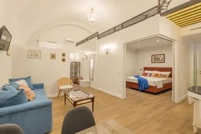 a living room with a blue couch and a bed at Pantheon Apartments - Piccola Roma in Rome