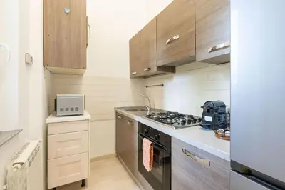 a kitchen with wooden cabinets and a stove top oven at A 10 min da San Giovanni Casa Indipendente in Rome