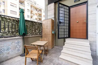a patio with a table and chairs and a umbrella at A 10 min da San Giovanni Casa Indipendente in Rome