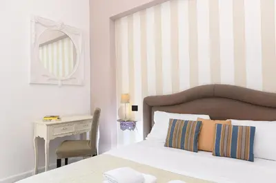 a bedroom with a bed and a desk and a mirror at Bernini al Borgo in Rome