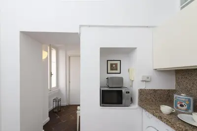 a kitchen with white cabinets and a microwave at Bernini al Borgo in Rome