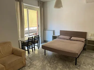 a bedroom with a bed and a chair and a table at Apartment Roma San Pietro in Rome