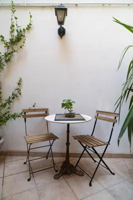 a table and two chairs next to a white wall at Romantic Suite nel Cuore di Roma - Piazza Navona - in Rome