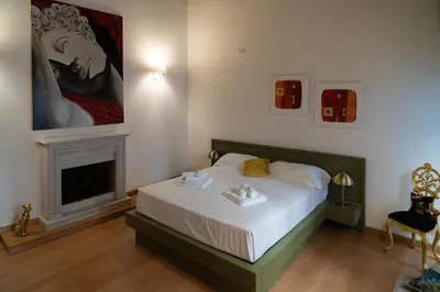 a bedroom with a bed with a fireplace and a painting at Romantic Suite nel Cuore di Roma - Piazza Navona - in Rome