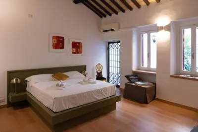 a bedroom with a large bed and two windows at Romantic Suite nel Cuore di Roma - Piazza Navona - in Rome