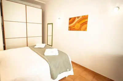 a bedroom with a white bed and a mirror at la casa sul cortile in Rome