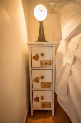 a night stand with a lamp on top of a bed at la casa sul cortile in Rome