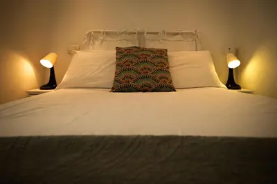 a bed with two lamps and a pillow on it at la casa sul cortile in Rome