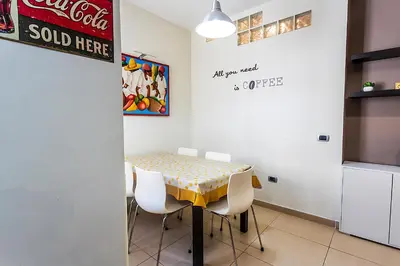 a dining room with a table and white chairs at Naos C&G Hospitium in Rome