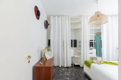 a bedroom with white curtains and a bed and a table at iFlat Colosseum Modern & Peaceful Design Apt in Rome