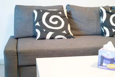 a brown couch with black and white pillows on it at House in the City in Rome