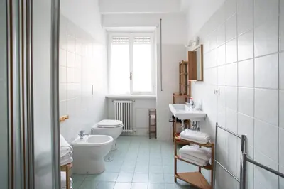 a white bathroom with a toilet and a sink at House in the City in Rome