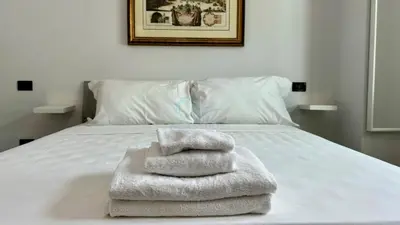 a white bed with towels on top of it at Contemporary Comfort Stylish Modern Apartment in Rome