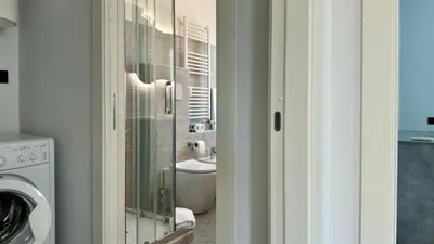 a bathroom with a sink and a washing machine at Contemporary Comfort Stylish Modern Apartment in Rome