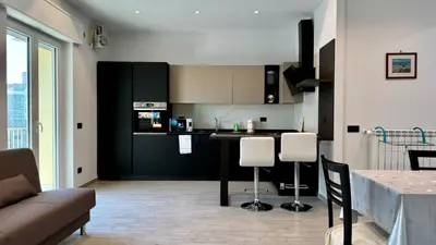 a kitchen with black cabinets and a table and chairs at Contemporary Comfort Stylish Modern Apartment in Rome