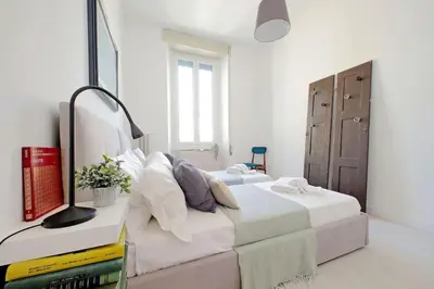 a bedroom with two beds with white sheets at Eroi Spacious Apartment in Rome