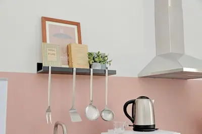 a shelf above a kitchen counter with utensils on it at Eroi Spacious Apartment in Rome
