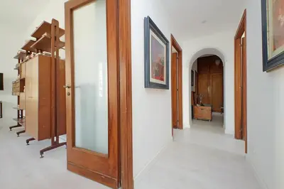 a hallway with wooden doors and paintings on the walls at Eroi Spacious Apartment in Rome