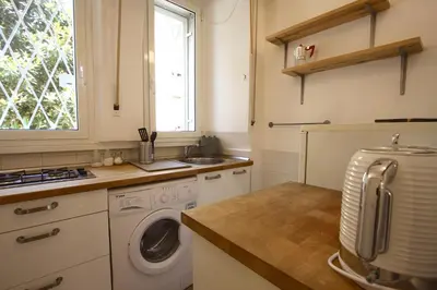 a kitchen with a washing machine and a sink at Garbatella 2BR Holiday House in Rome