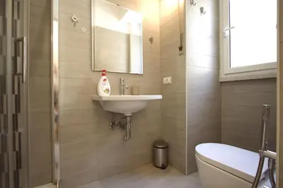 a bathroom with a sink and a toilet and a mirror at Garbatella 2BR Holiday House in Rome