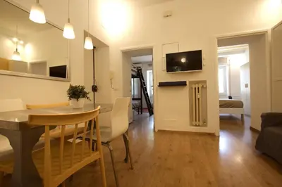 a living room with a table and a dining room at Garbatella 2BR Holiday House in Rome