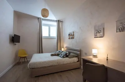a bedroom with a bed and a desk and a window at 2passi dal Colosseo in Rome
