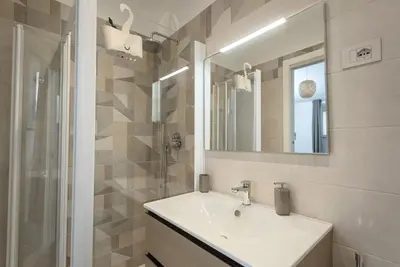 a bathroom with a sink and a shower and a mirror at 2passi dal Colosseo in Rome