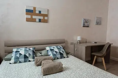 a bedroom with a bed with a chair and a desk at 2passi dal Colosseo in Rome
