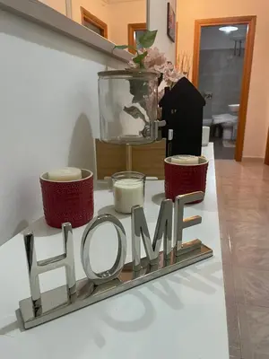 a sign with the word bloom on a table with candles at San Lorenzo Private Apartment in Rome